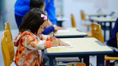 A young student writing at a desk.