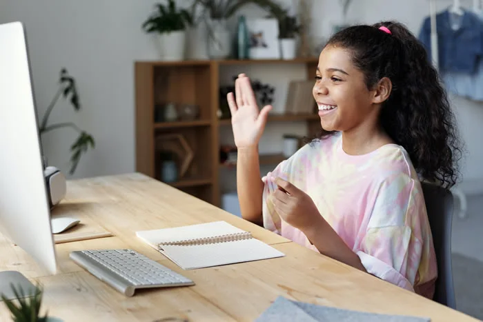 Smiling student raising hand during an online learning session. online class.